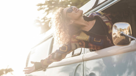Woman in a van enjoying the sun and win in her hair